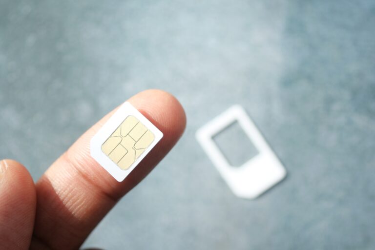 Karta SIM trzymana na palcu osoby, w tle rozmyta ramka karty. Ta osoba też może skorzystać z oferty Airalo.