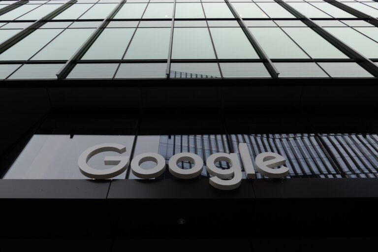 Logo Google na szklanym budynku biurowym.
