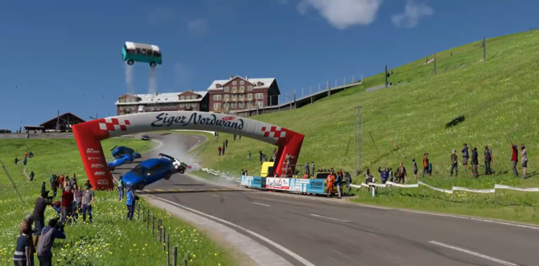 Samochody sportowe uczestniczące w wyścigu zderzają się i unoszą w powietrzu na trasie Eiger Nordwand. W tle widoczne budynki na zielonych wzgórzach oraz tłum kibiców obserwujących wydarzenie. To zrzut ekranu z gry Gran Turismo 7