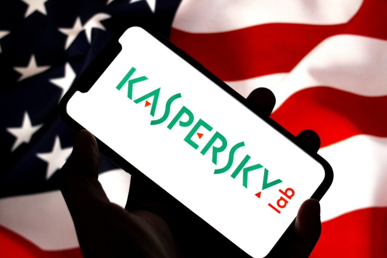 Logo Kaspersky na ekranie telefonu, w tle flaga Stanów Zjednoczonych.