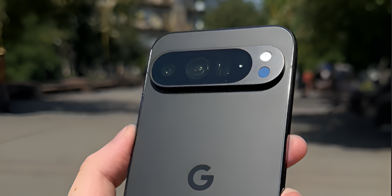 Telefon komórkowy Google Pixel 9 Pro trzymany w dłoni na tle parku.