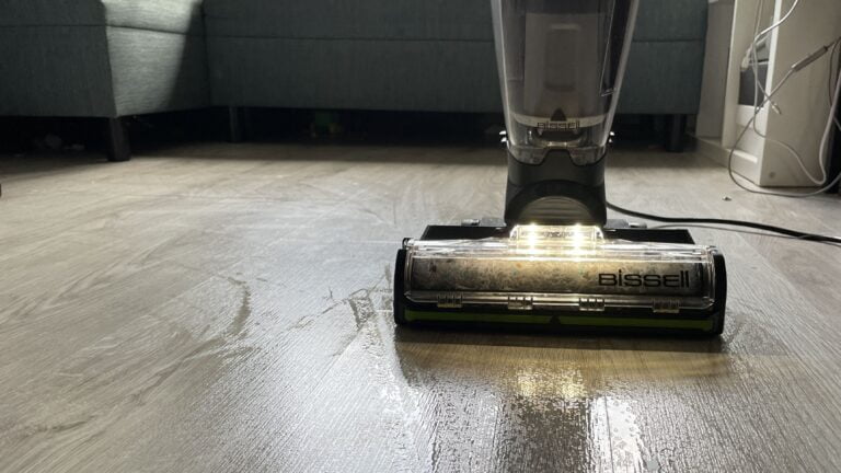 Odkurzacz Bissell czyszczący mokrą podłogę z jasnych paneli w salonie.