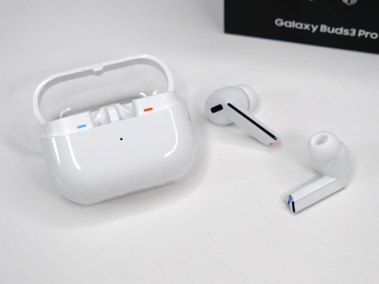 Białe słuchawki bezprzewodowe z etui i opakowaniem "Galaxy Buds3 Pro" w tle.