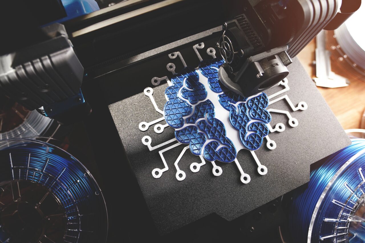 Drukarka 3D drukująca niebieskie elementy w kształcie mózgu.