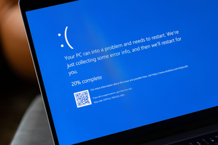 Ekran niebieskiego błędu (Blue Screen of Death) na komputerze z systemem Windows. Ekran zawiera komunikat o błędzie "Your PC ran into a problem and needs to restart," kod QR, oraz tekst o kodzie zatrzymania "CRITICAL_PROCESS_DIED".