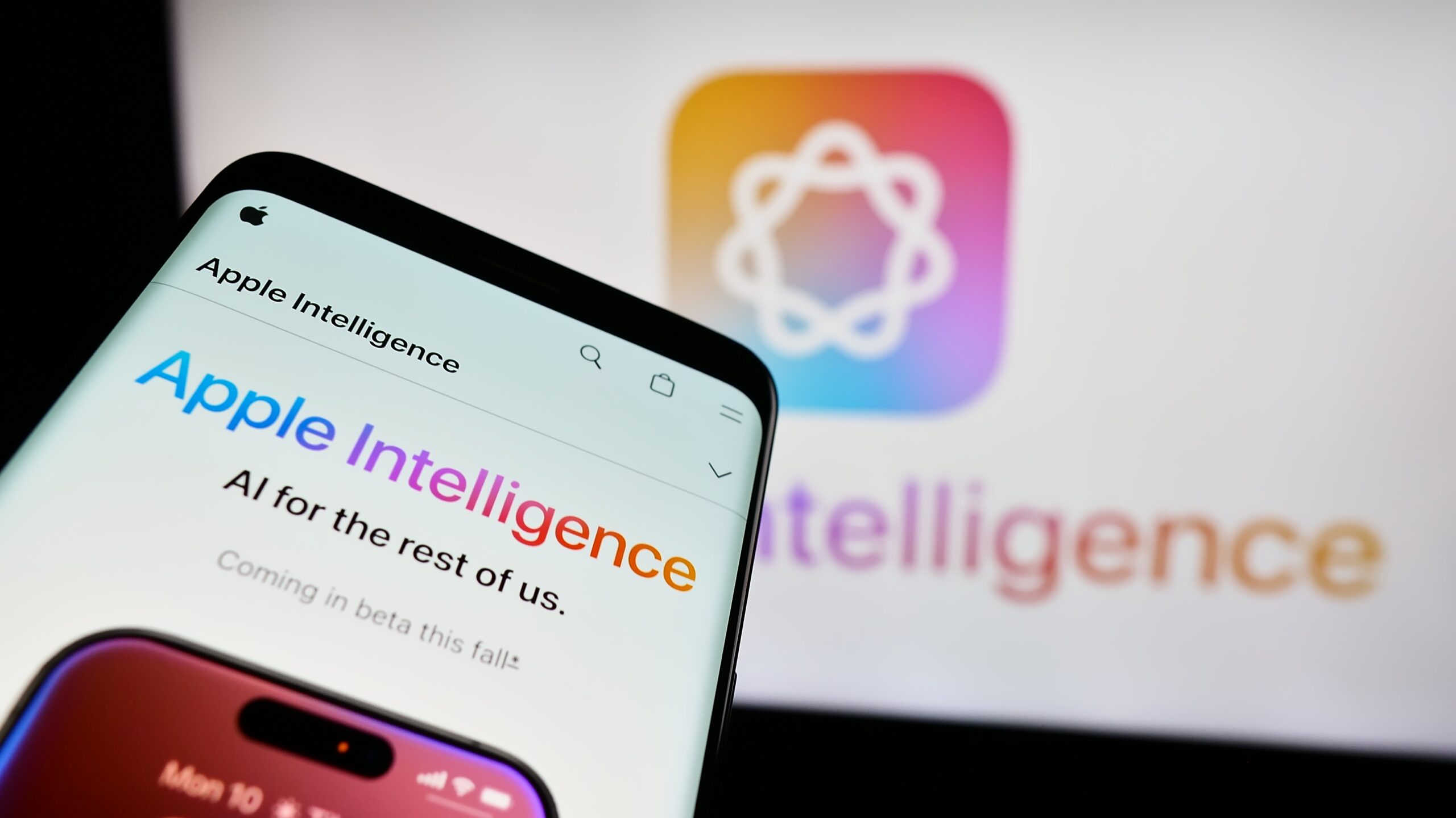 Telefon z otwartą stroną "Apple Intelligence" na tle logo Apple Intelligence.