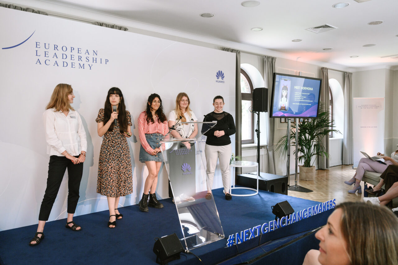 Huawei Summer School for Female Leadership. Grupa pięciu kobiet prezentujących na scenie podczas wydarzenia European Leadership Academy, obok logo Huawei i ekranu z prezentacją.