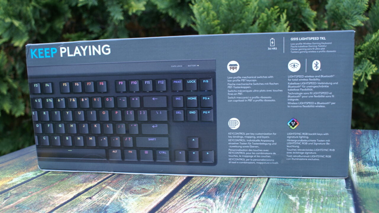 Opakowanie klawiatury Logitech G915 LIGHTSPEED TKL, na tle zielonych krzewów.