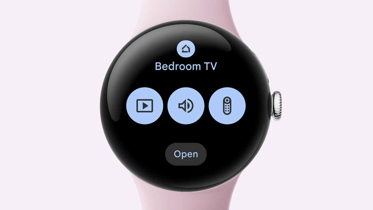 Smartwatch z aplikacją do sterowania telewizorem w sypialni, pastelowy pasek, ekran z trzema ikonami: odtwarzanie wideo, głośność i pilot.