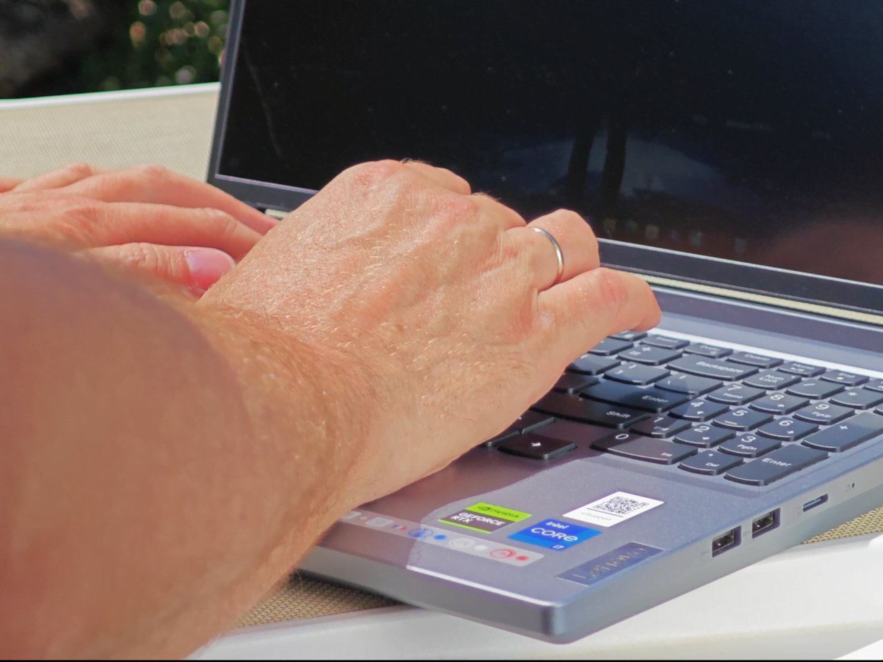 Laptop vs mobilna konsola, Lenovo Legion go Dłonie piszące na klawiaturze laptopa.