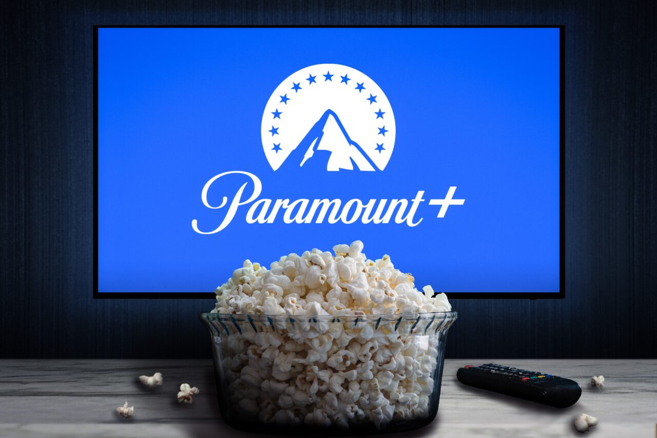 Ekran telewizora z logo Paramount+, obok miska popcornu i pilot.