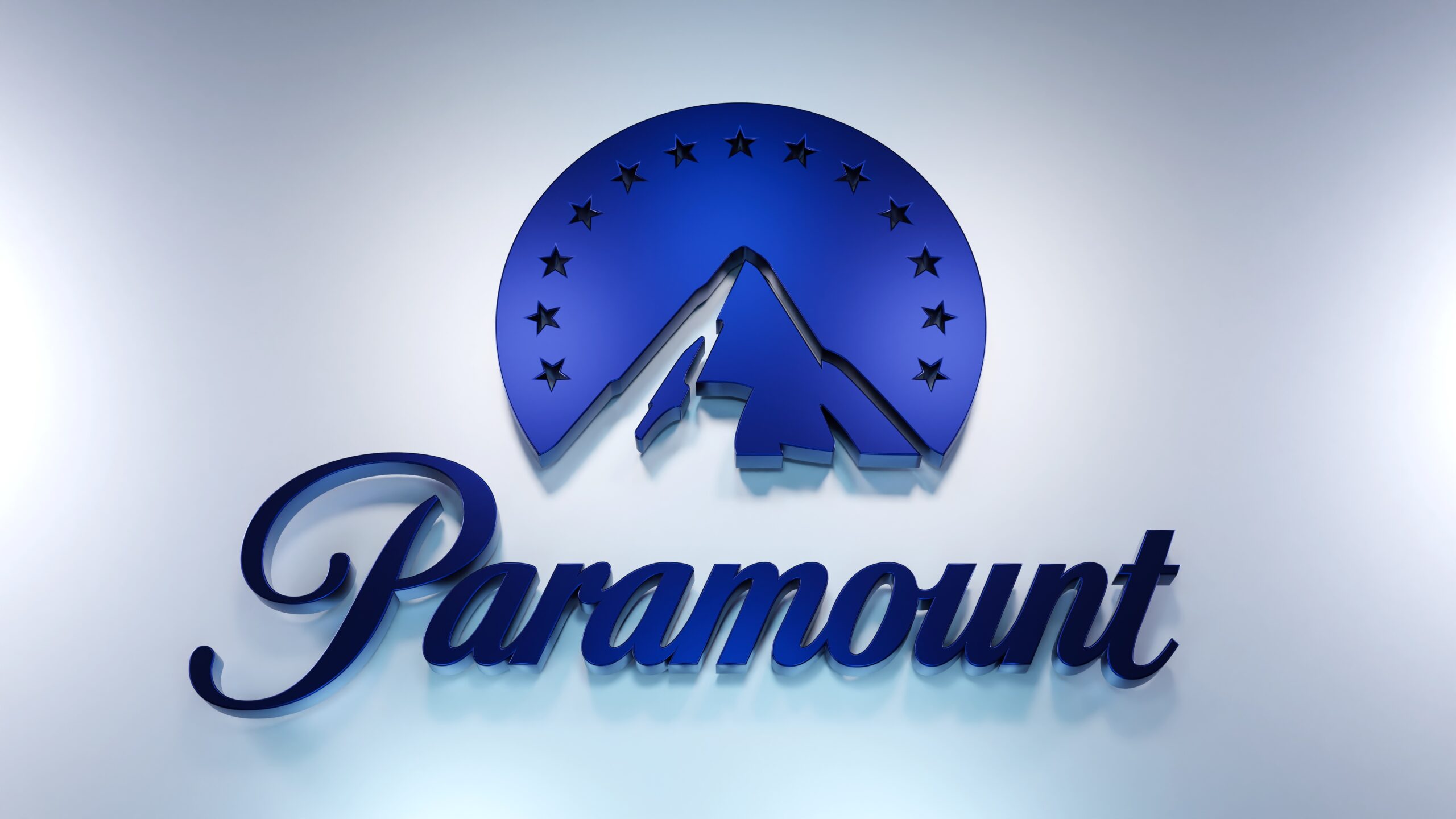 Logo Paramount Pictures na białym tle, niebieska góra z dwunastoma gwiazdami oraz napis „Paramount” w kursywie.