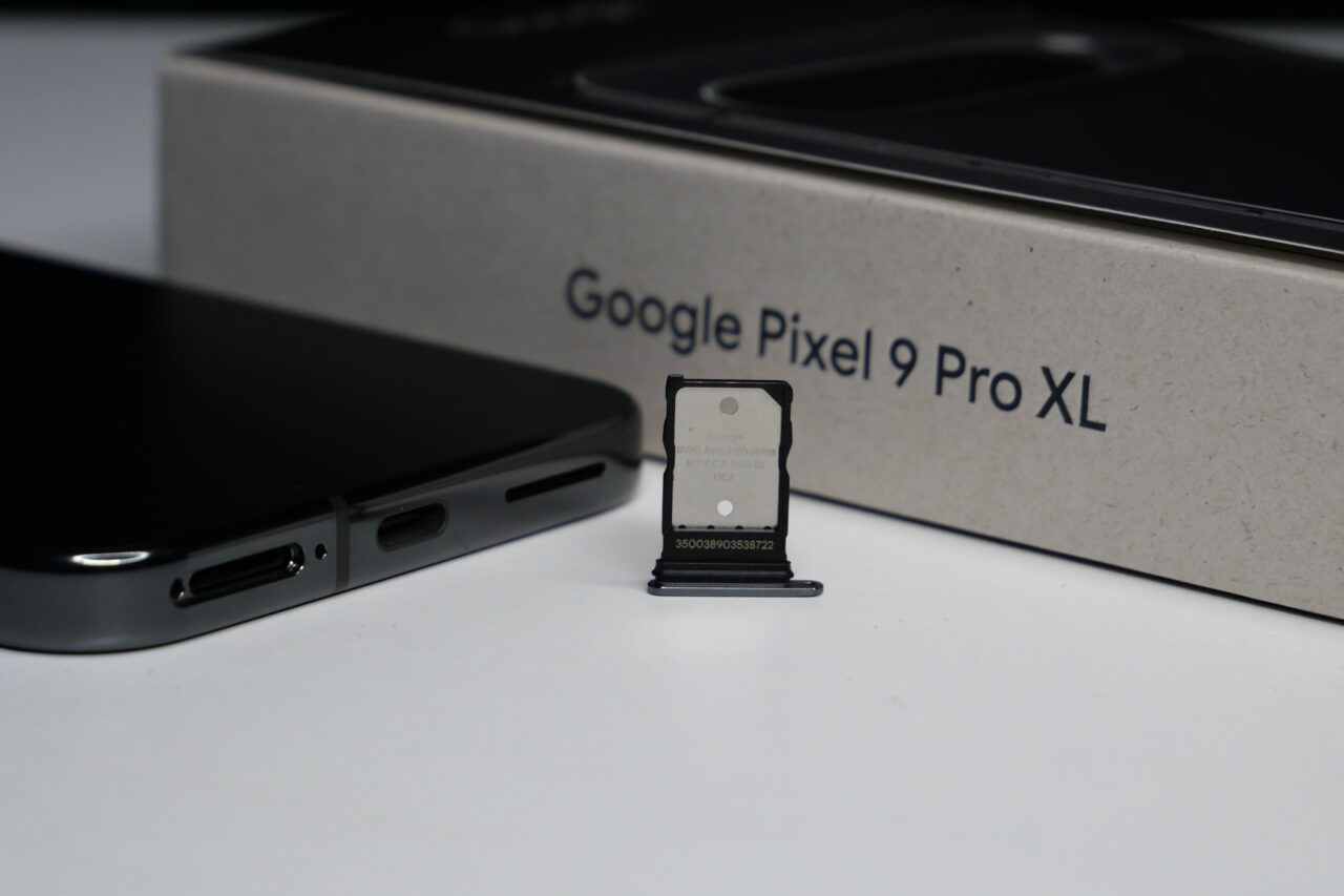 Google Pixel 9 Pro XL, podstawka na kartę SIM oraz telefon na białym tle.