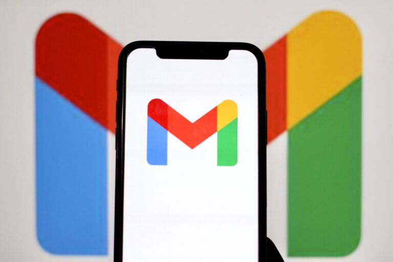 Logo Gmail na ekranie smartfona na tle większego logo Gmail.