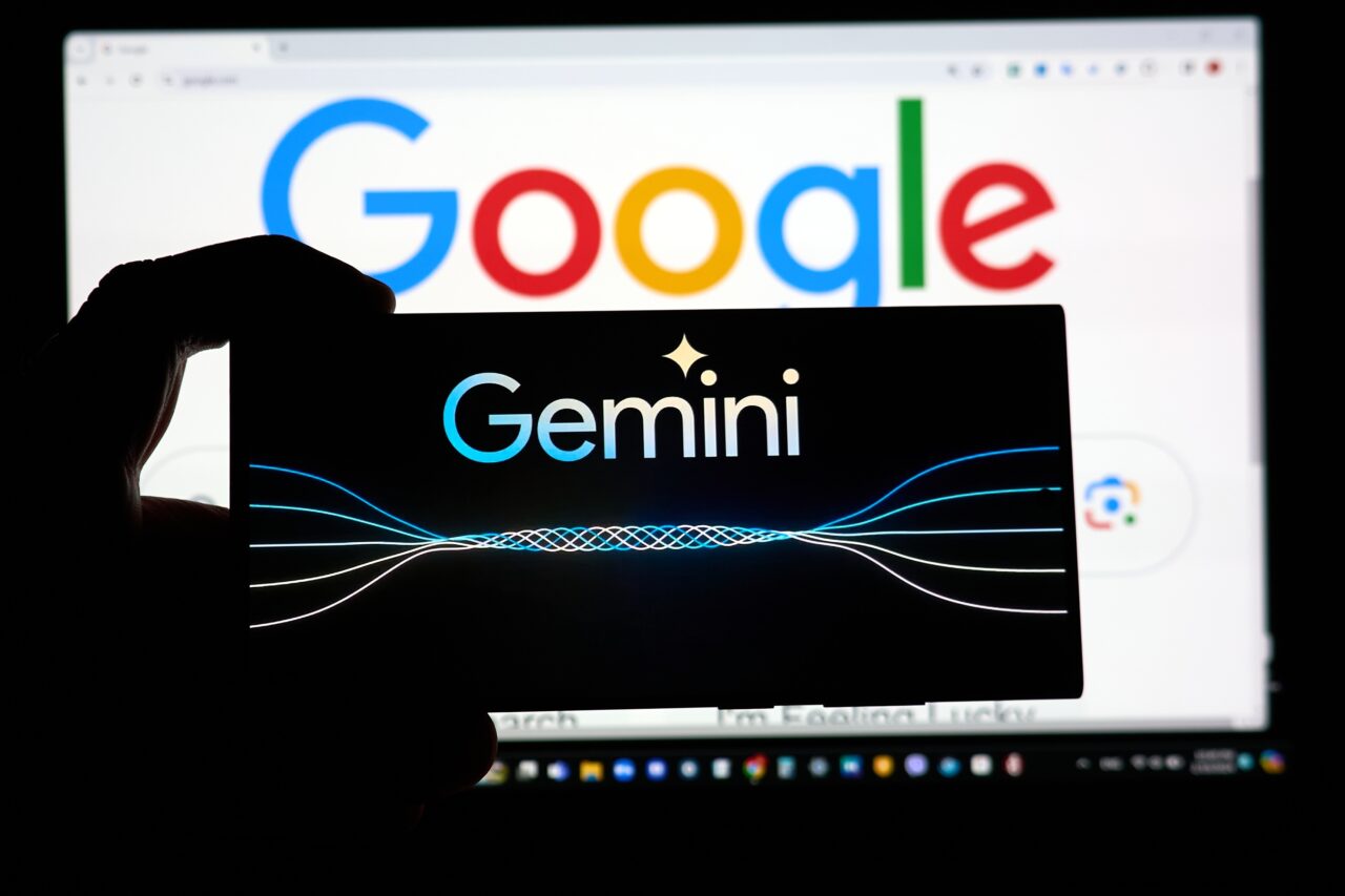 aplikacja gemini - Osoba trzymająca ekran z logo "Gemini" na tle ekranu z logo "Google".