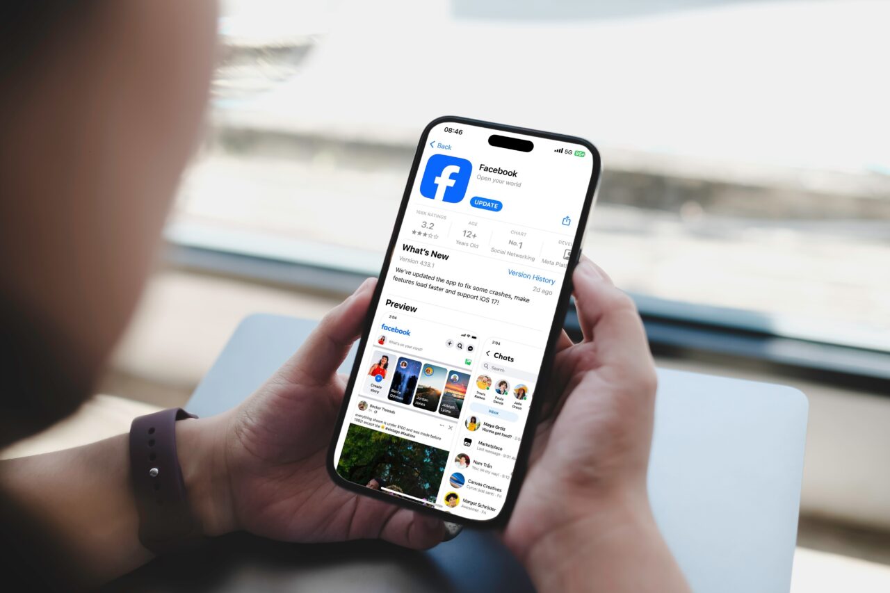 Osoba trzymająca smartfon z otwartą stroną aktualizacji aplikacji Facebook w sklepie App Store.