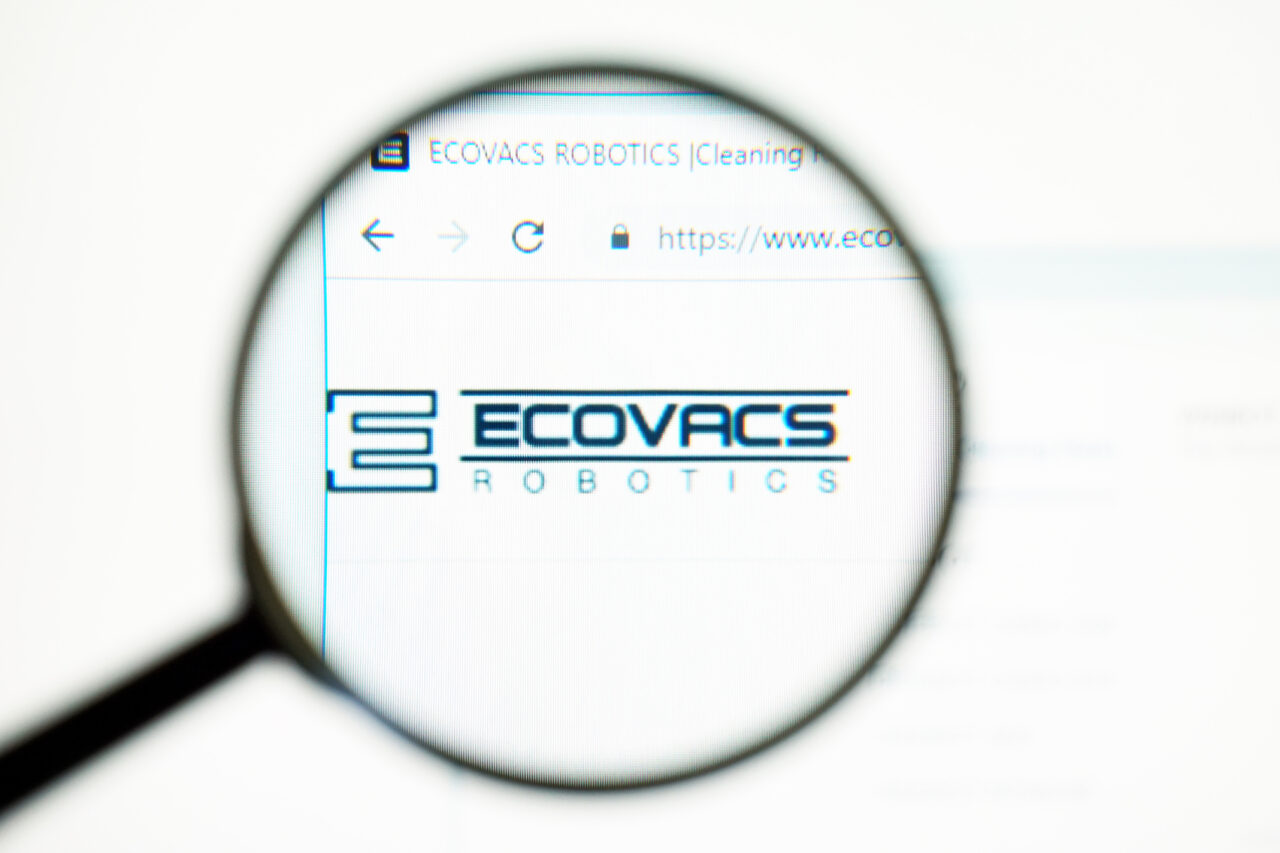 Logo ECOVACS Robotics widoczny przez lupę.