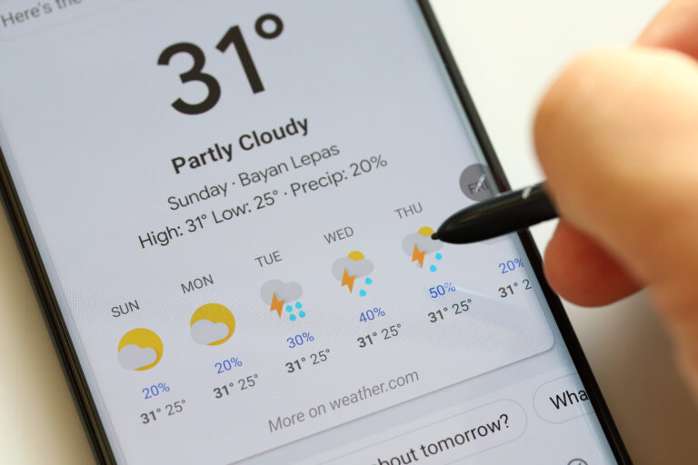 Pogoda Google. Ekran smartfona z aplikacją pogodową pokazującą prognozę na tydzień, osoba używająca stylusa.