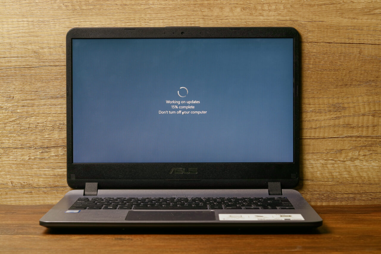 Laptop ASUS aktualizujący system Windows, ekran pokazuje komunikat "Working on updates 15% complete Don't turn off your computer".