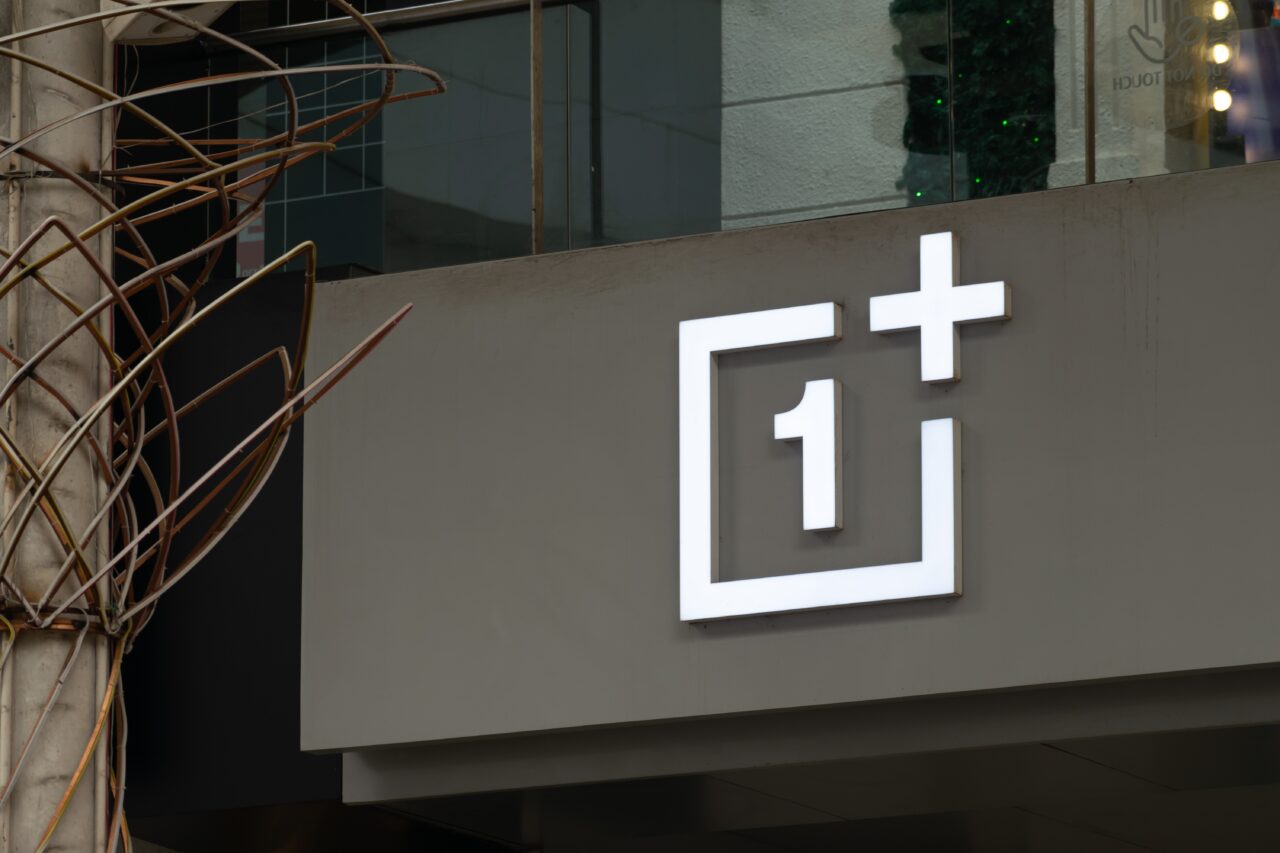 Logo firmy OnePlus na szarym tle.