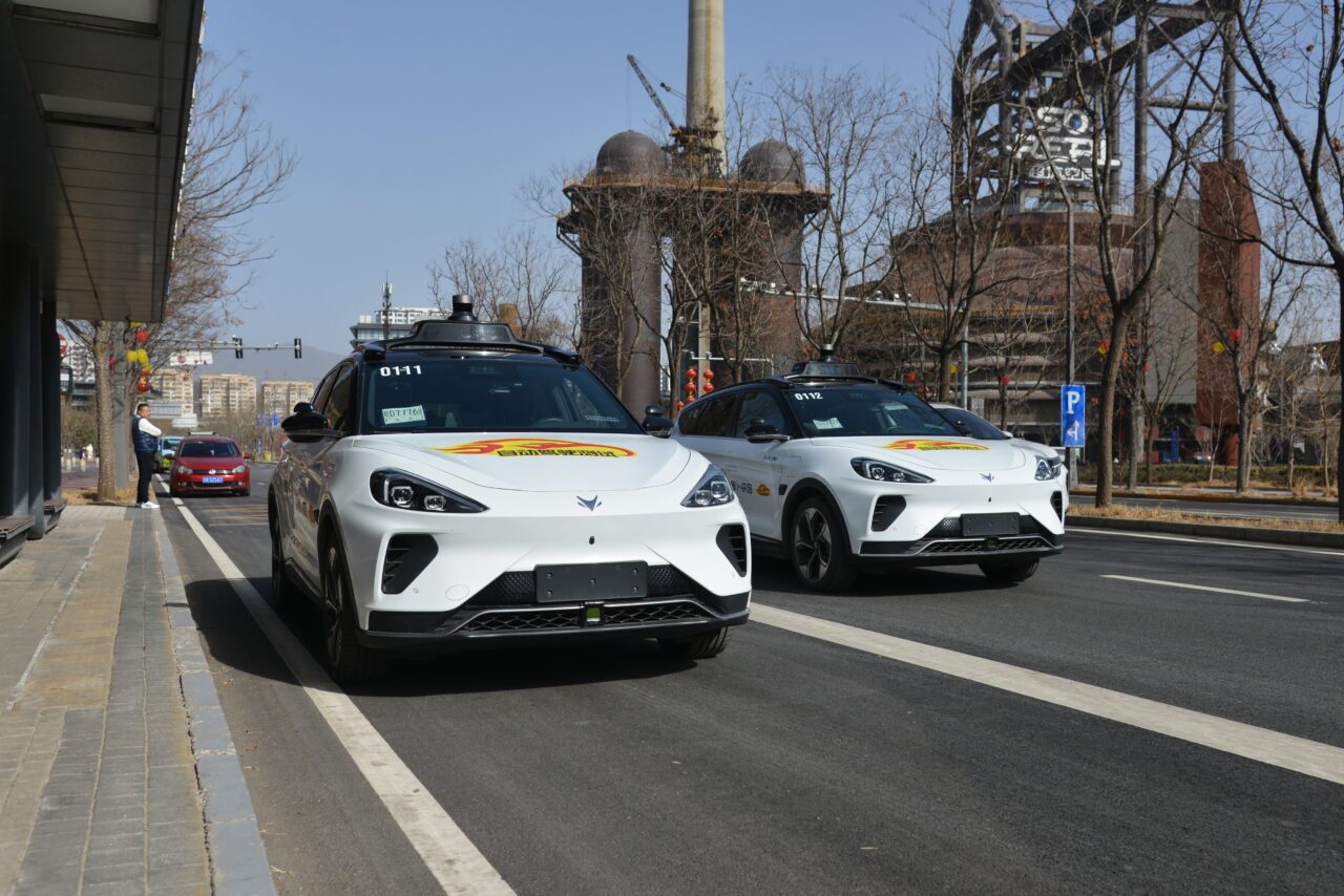 Robotaxi. Dwa autonomiczne samochody elektryczne na ulicy w miejskim otoczeniu.