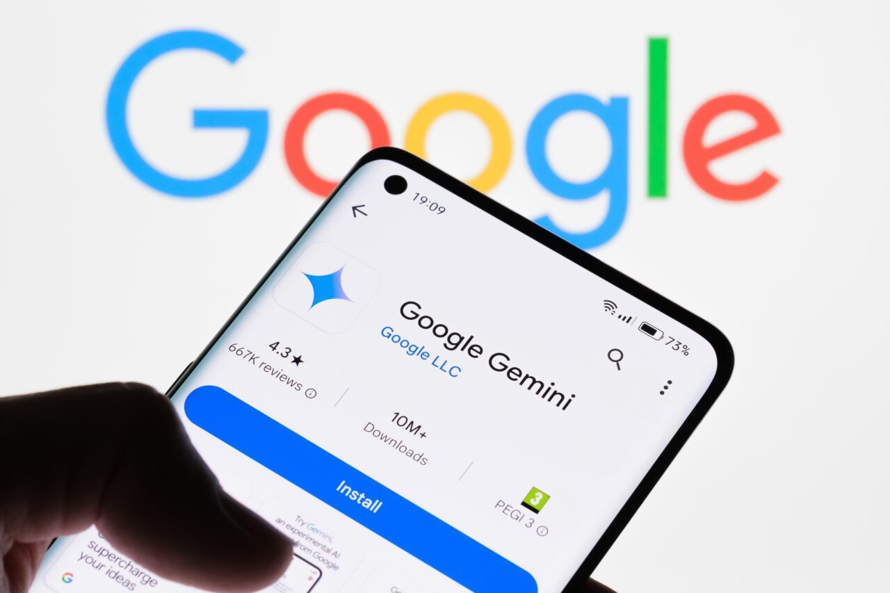 Aplikacja "Google Gemini" na ekranie smartfona na tle logo Google.