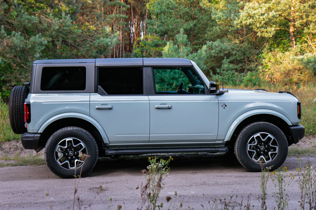 Test Ford Bronco Outer Banks w plenerze, widok z boku na leśnej drodze.