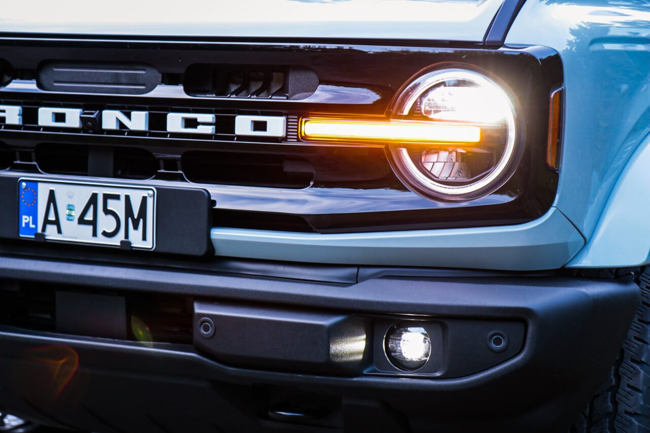 Test Ford Bronco Outer Banks, zbliżenie na przednie reflektory i grill z napisem "Bronco".