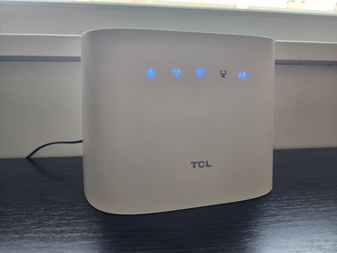 biały router TCL stojący na stole