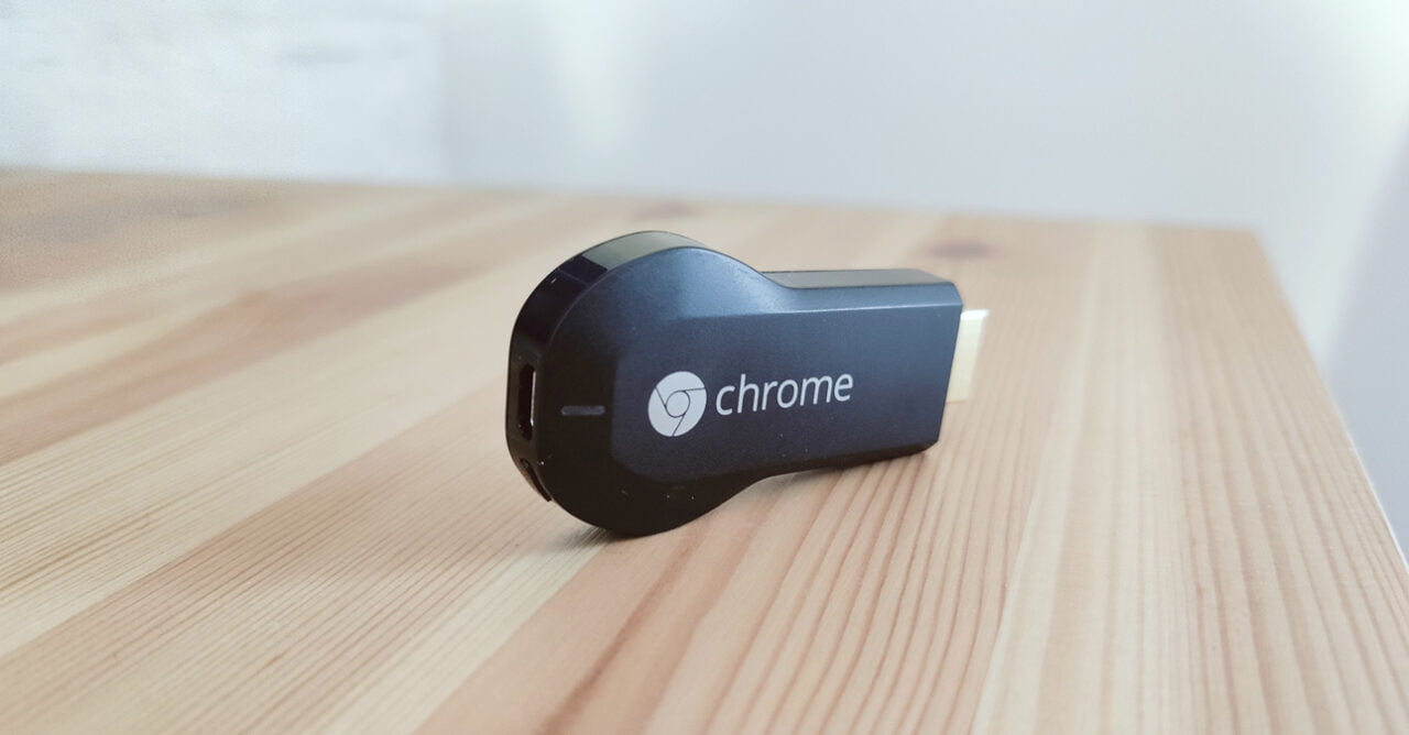 Czarny Chromecast leżący na drewnianym stole.