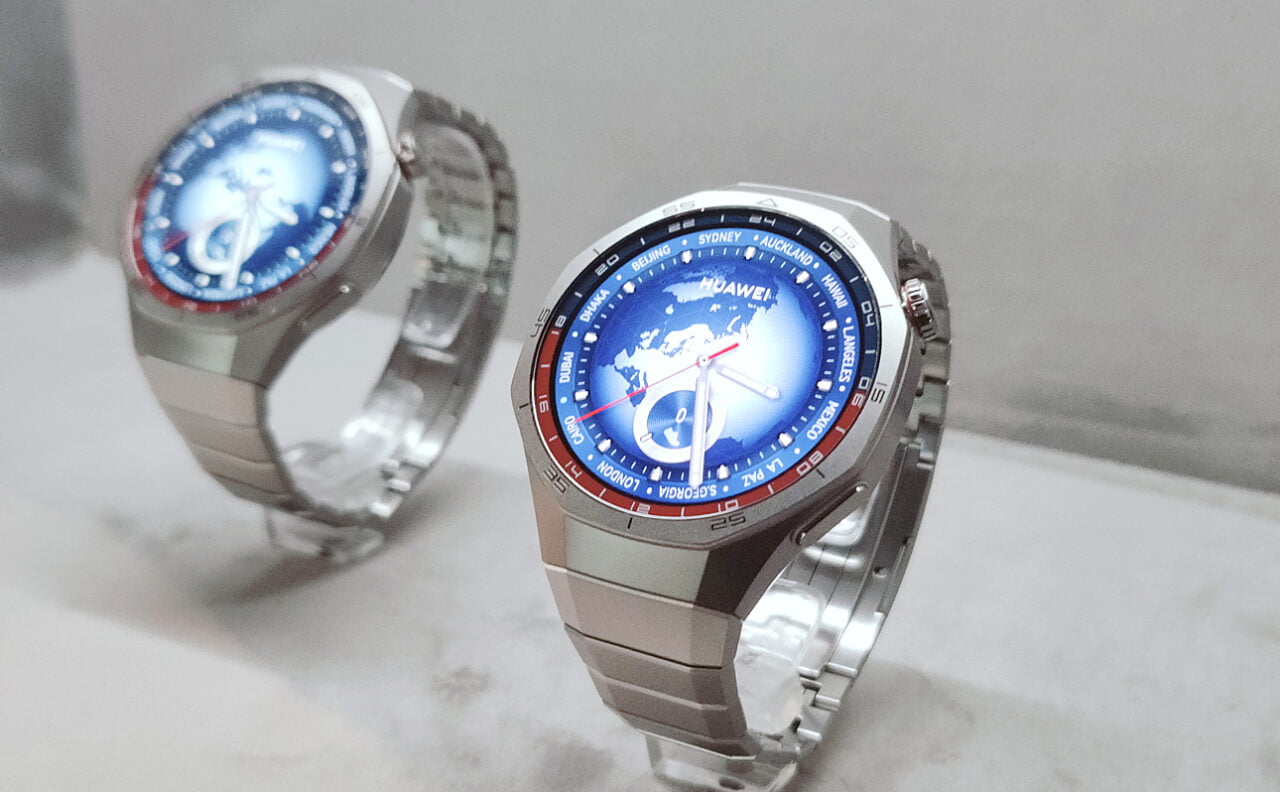 Dwa srebrne zegarki Huawei Watch GT 5 Pro z wyświetlaczami cyfrowymi pokazującymi mapę świata i główne miasta.