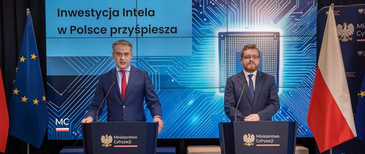 Dwóch mężczyzn stoi przy podium na tle ekranu z napisem "Inwestycja Intela w Polsce przyspiesza," obok flag Polski i Unii Europejskiej.