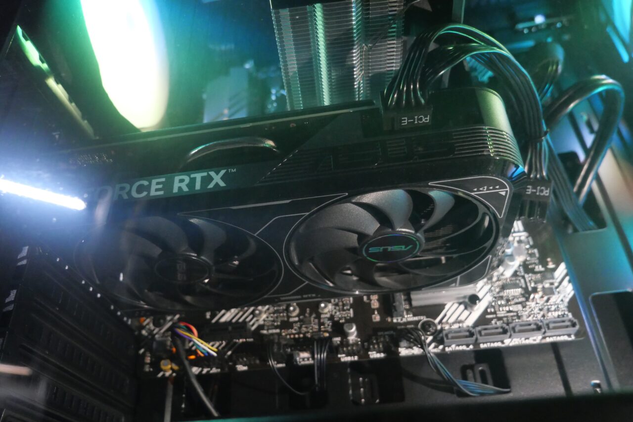 Wnętrze komputera PC z kartą graficzną Nvidia GeForce RTX, wentylatorami ASUS i podświetleniem LED.