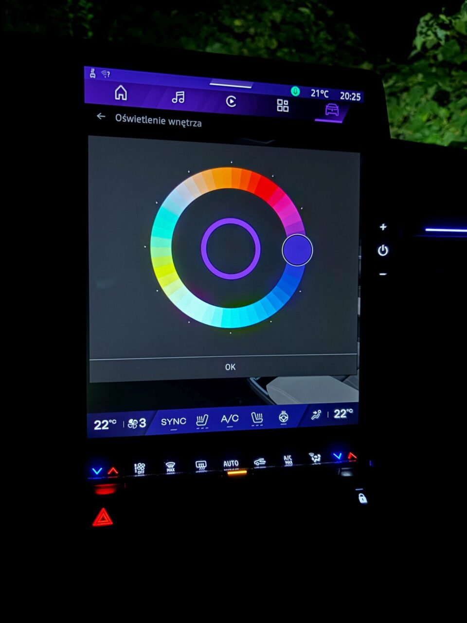 Ekran dotykowy samochodu pokazujący ustawienia oświetlenia wnętrza z opcją wyboru koloru.