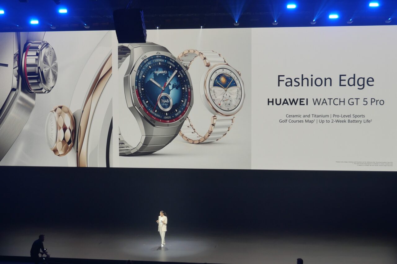 Prezentacja zegarków Huawei Watch GT 5 Pro na dużym ekranie, osoba na scenie oraz napisy: "Fashion Edge", "Huawei Watch GT 5 Pro", "Ceramic and Titanium | Pro-Level Sports Golf Courses Map1 | Up to 2-Week Battery Life2".