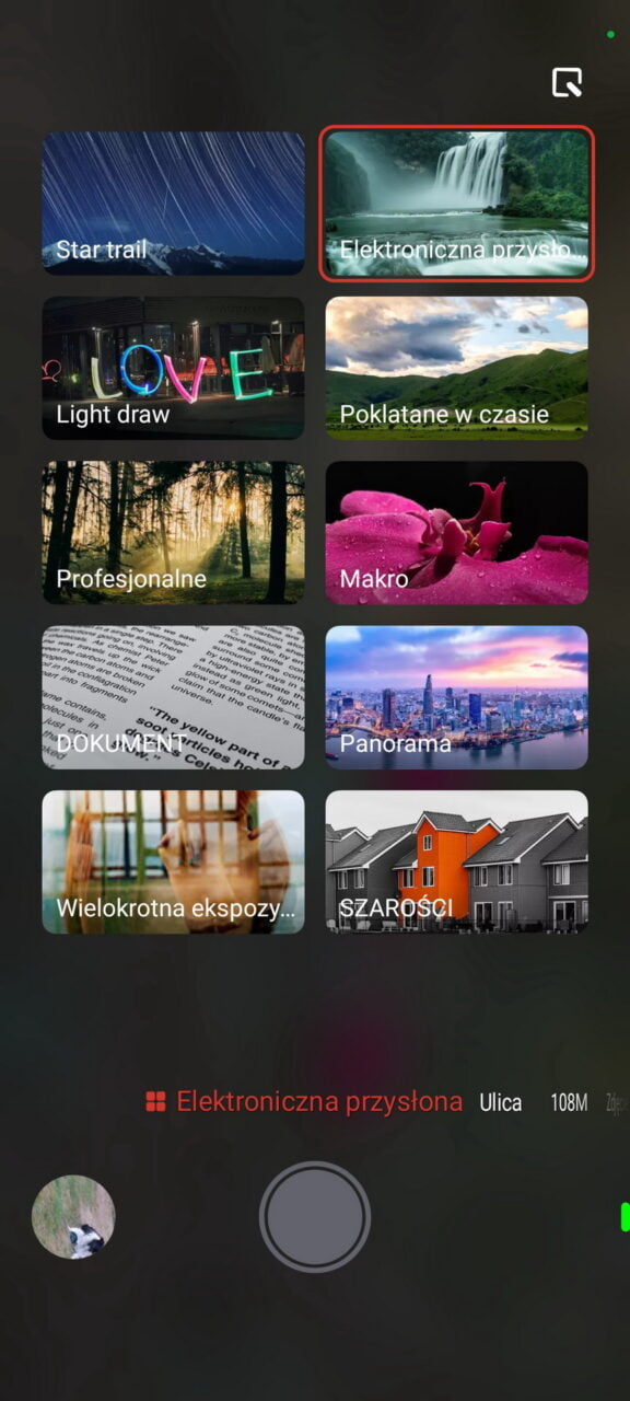 Interfejs wyboru trybu fotografowania z różnymi opcjami, takimi jak "Star trail", "Elektroniczna przysłona", "Light draw", "Poklatane w czasie", "Profesjonalne", "Makro", "DOKUMENT", "Panorama", "Wielokrotna ekspozycja" i "SZAROSCI".