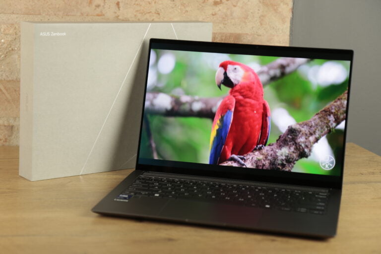 ASUS Zenbook S 14 z kolorowym wyświetlaczem i pudełkiem w tle, recenzja ASUS Zenbook S 14 UX5406.