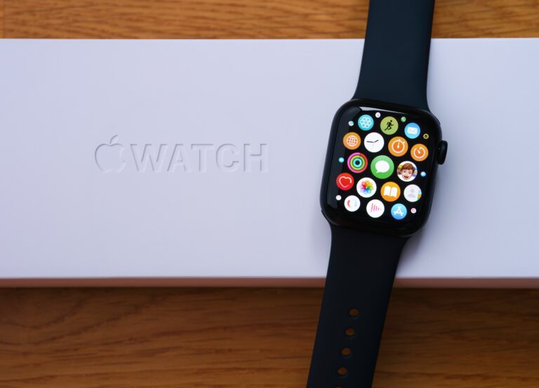 Zbliżenie na Apple Watch leżący na białym pudełku z napisem "Apple Watch".