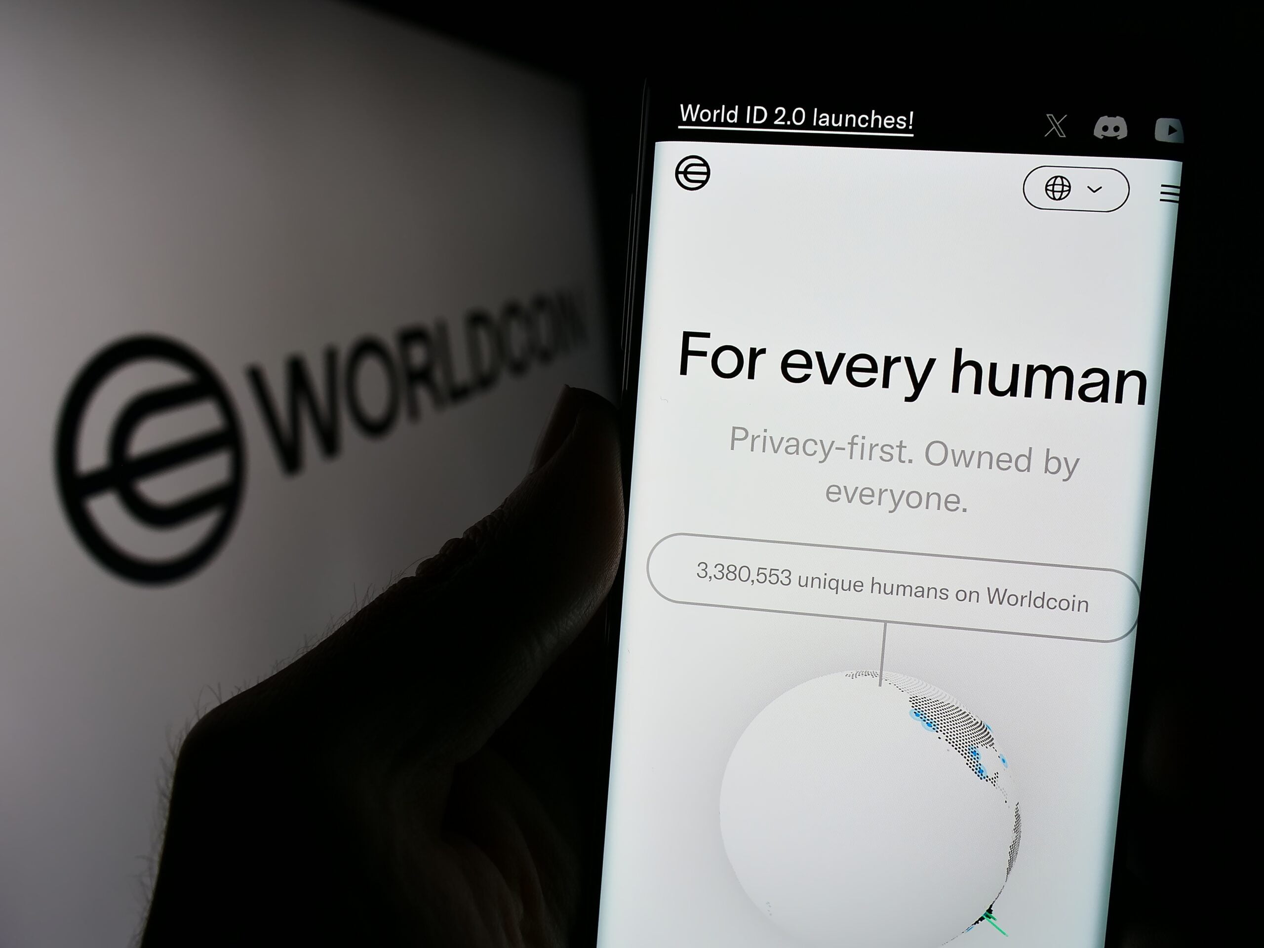 Logo i tekst Worldcoin na ekranie urządzenia mobilnego: "For every human. Privacy-first. Owned by everyone." oraz statystyki użytkowników.