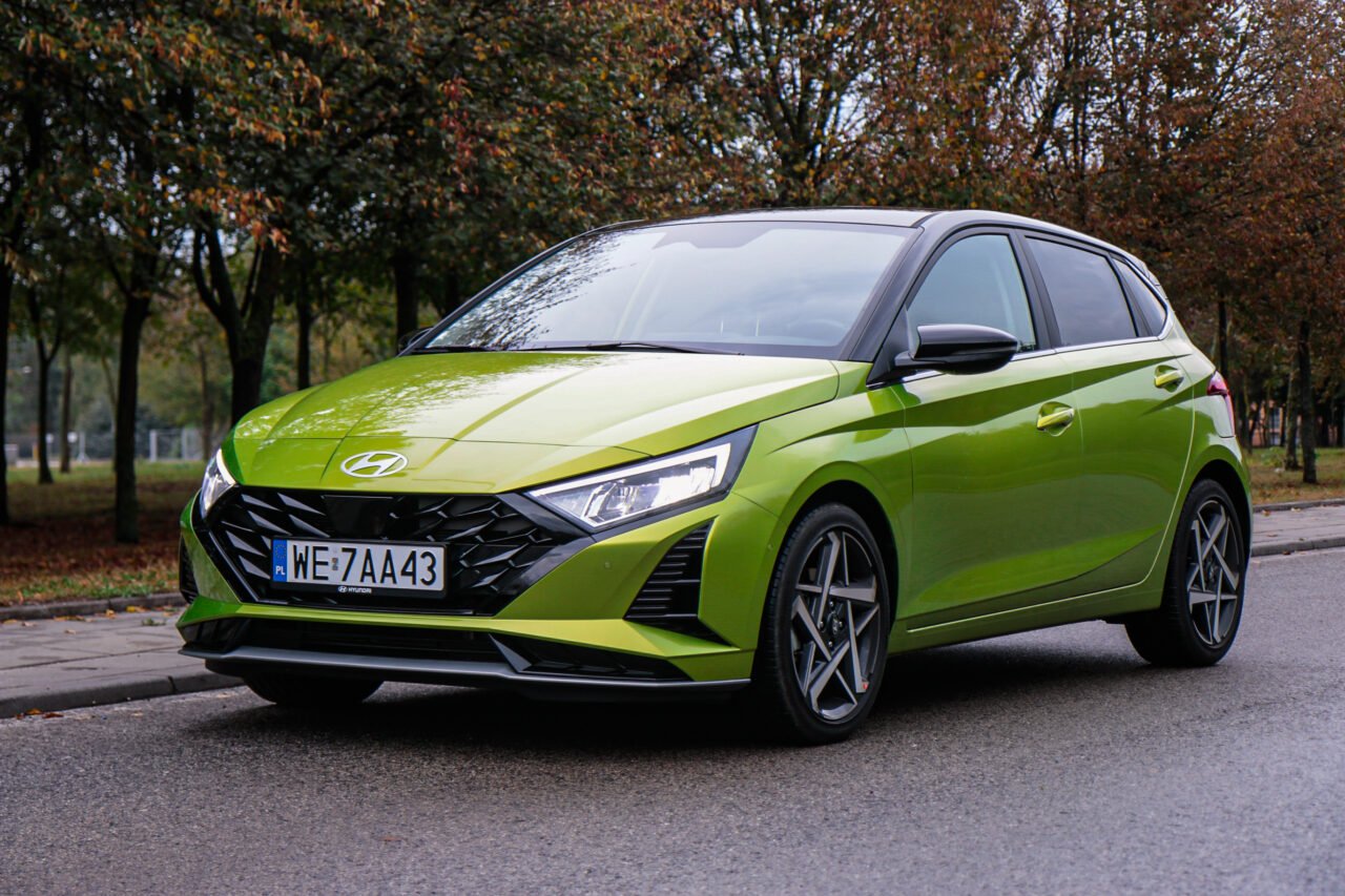 Test Hyundai i20 2024 w kolorze zielonym na tle drzew.