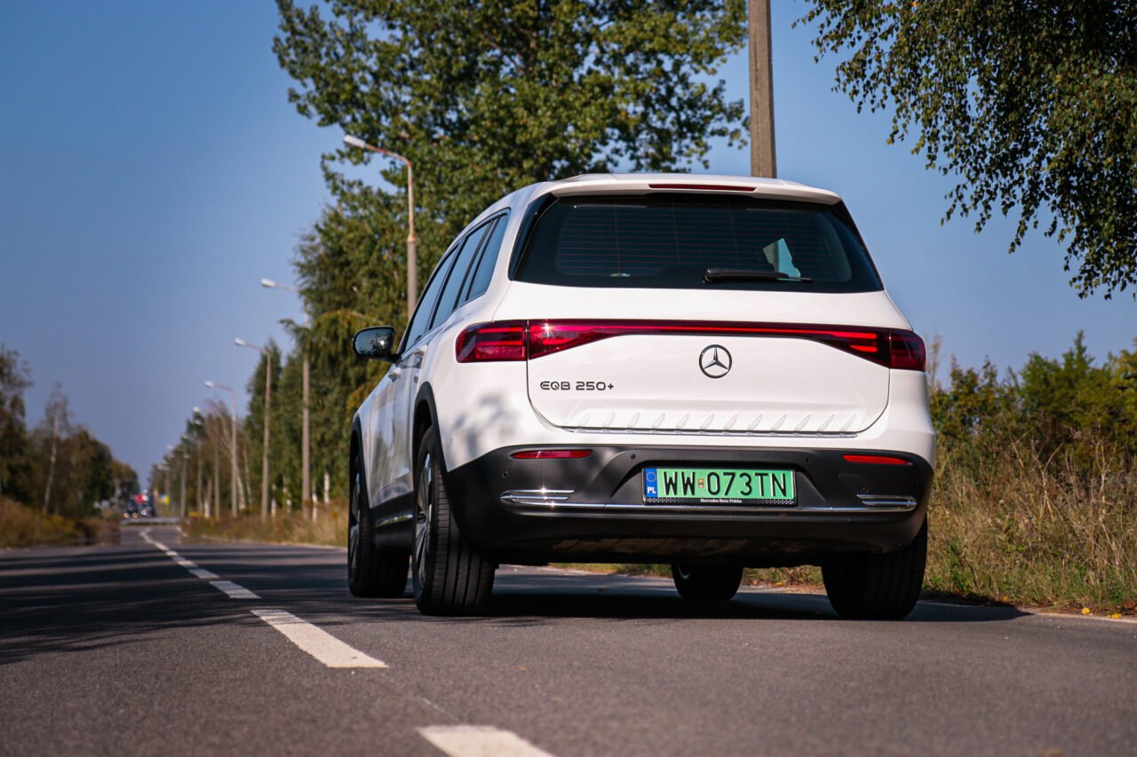 Test Mercedes EQB 250+, widok od tyłu na białą elektryczną terenówkę stojącą na drodze.