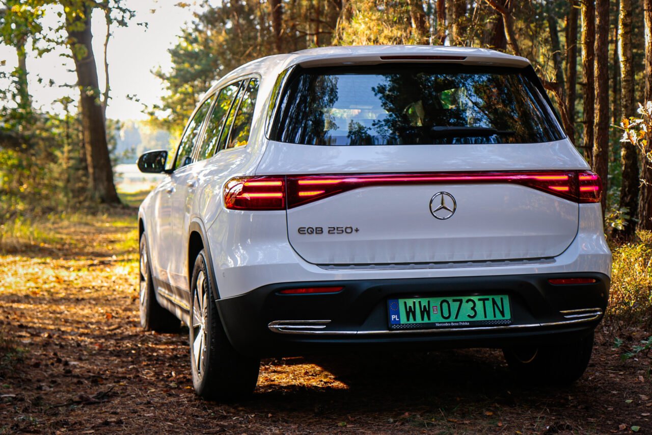 Biały samochód Mercedes EQB 250+ na leśnej drodze podczas testu.